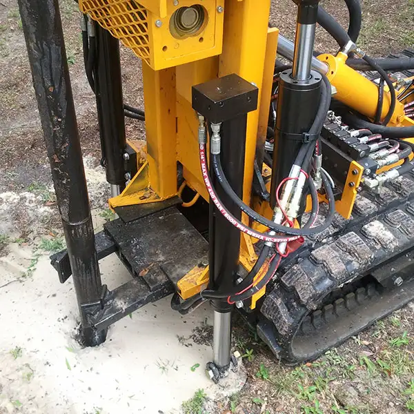 Drilling rig for compaction grounting with pipe clamp.